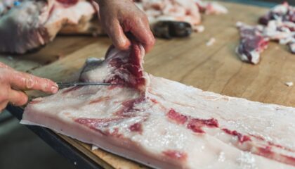 Closeup,Of,The,Hands,Of,A,Butcher,Cutting,Slices,Of